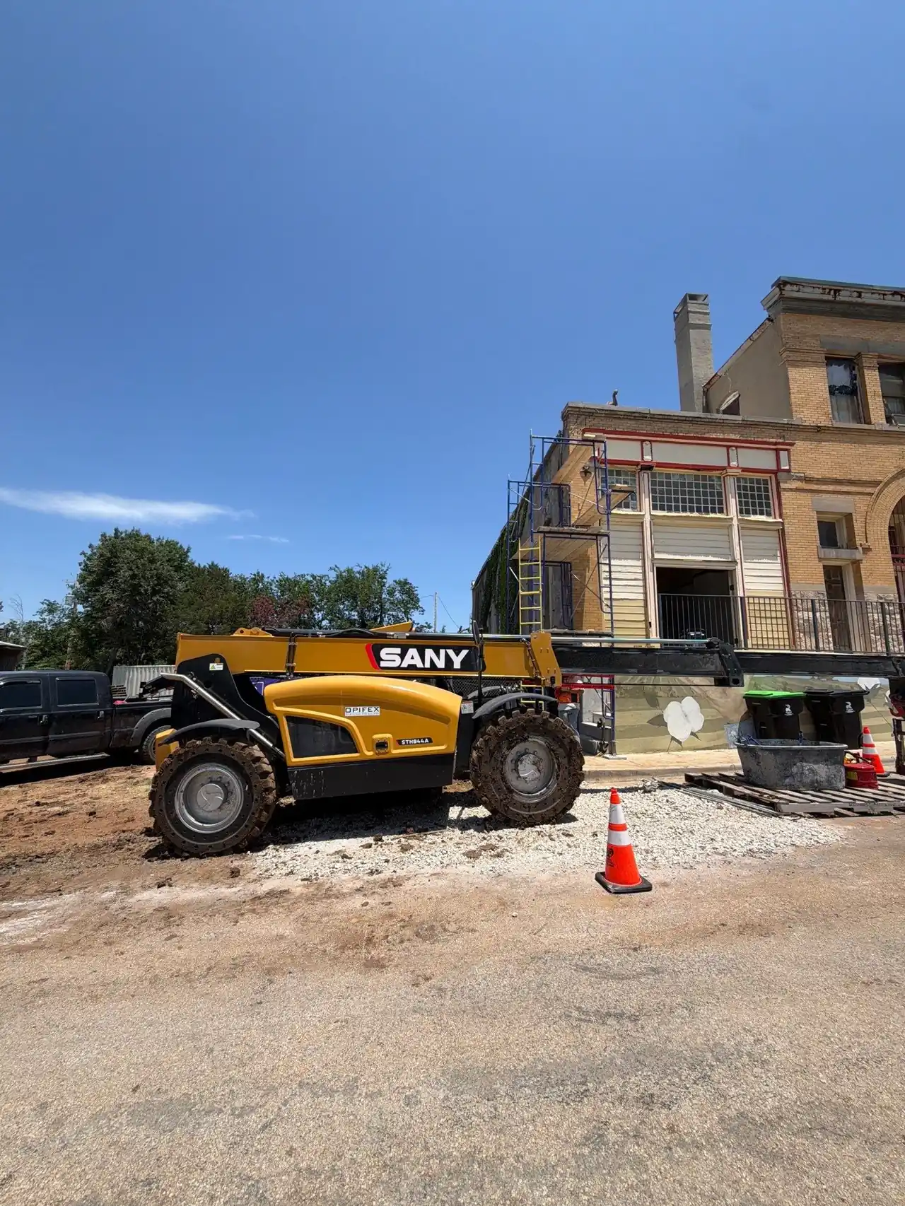 Equipment staged at a historic Pilot Point building during foundation restoration