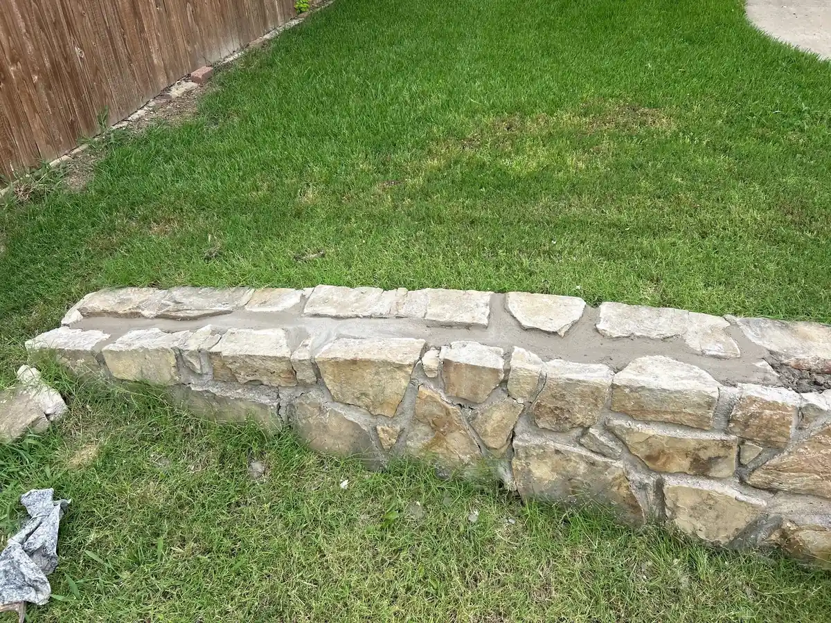 Finished dry stack stone retaining wall on a residential lawn